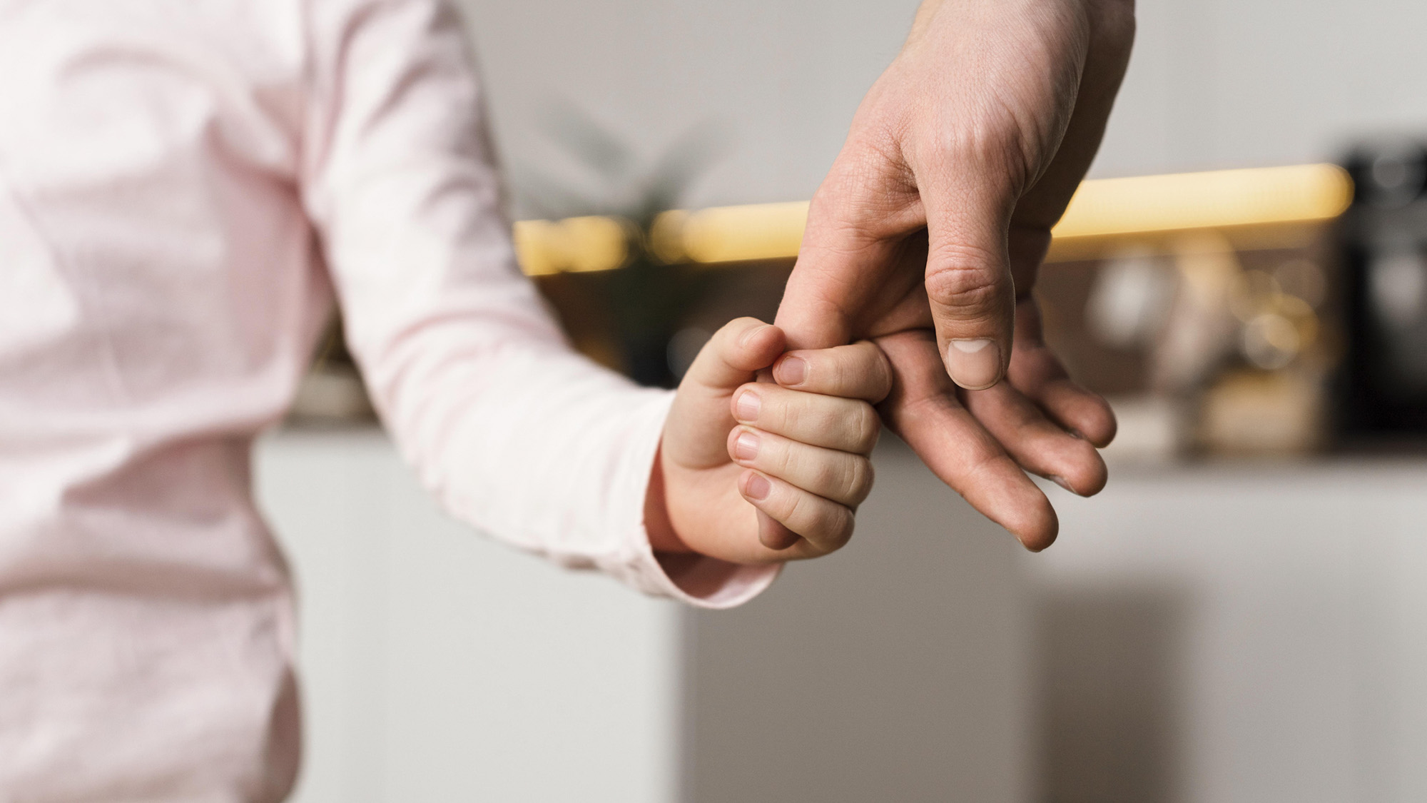 child holding hand of adult