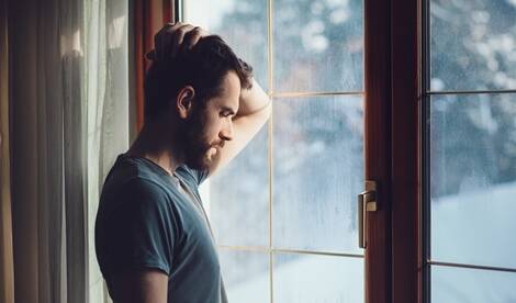 troubled man looking out window