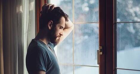 troubled man looking out window