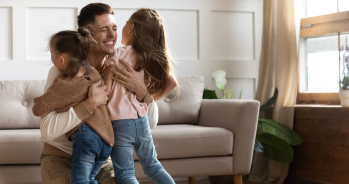 Father hugging two daughters