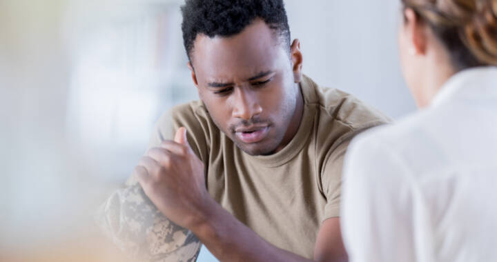 Man looking down while talking to mental health counselor